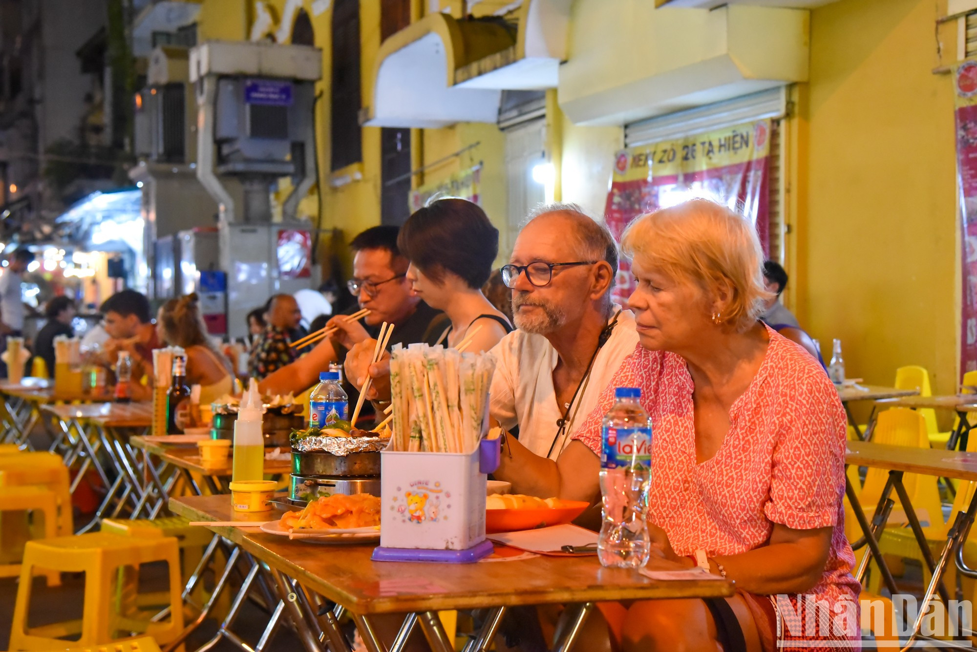 Los visitantes extranjeros disfrutan comidas en la calle Ta Hien. Los visitantes extranjeros disfrutan comidas en la calle Ta Hien.