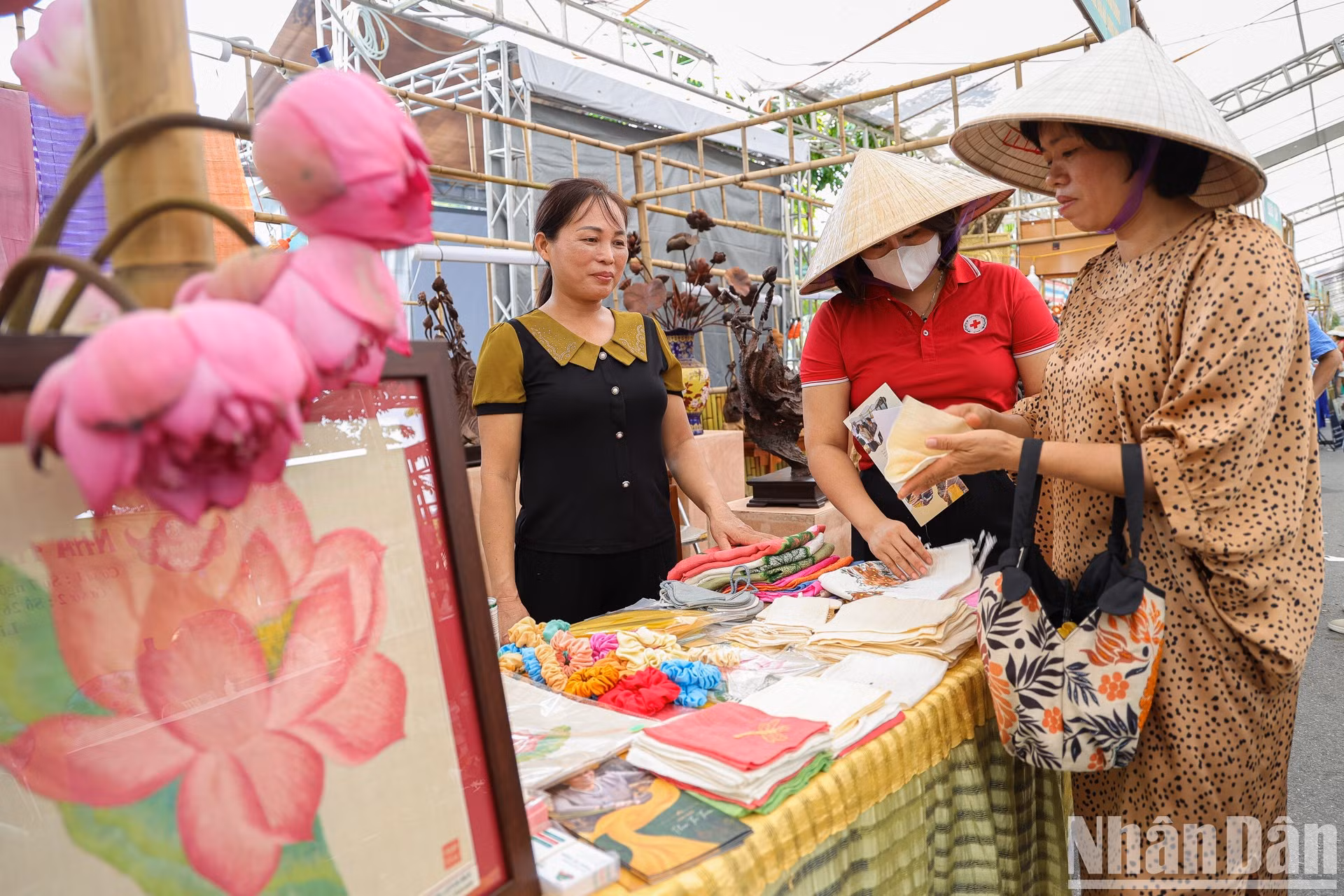 El stand de pañuelos de seda de loto con potencial para lograr cinco estrellas de OCOP de la artesana Phan Thi Thuan atrae a un gran número de visitantes.