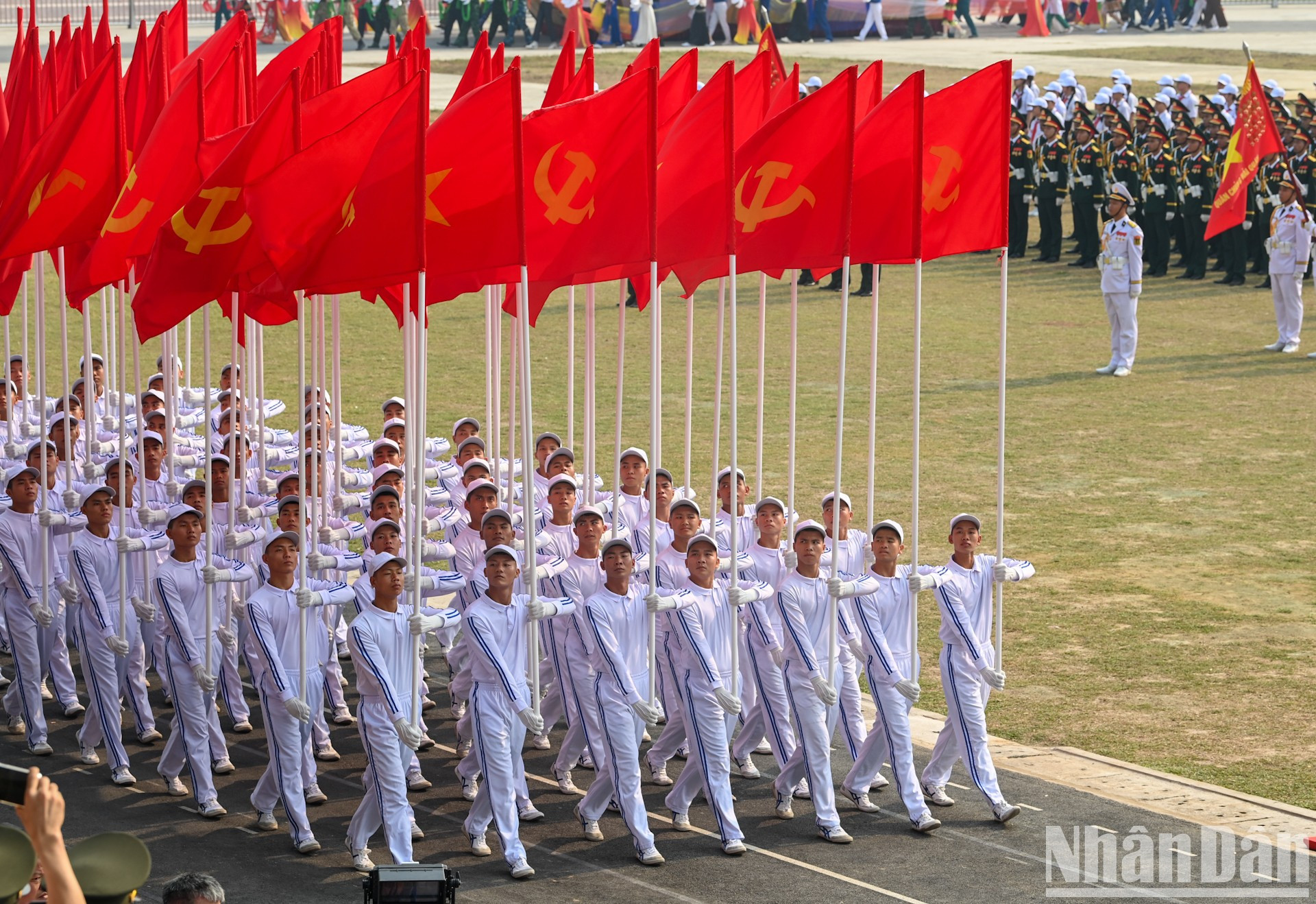 Bloque de banderas nacionales y del Partido desfila en el ensayo.