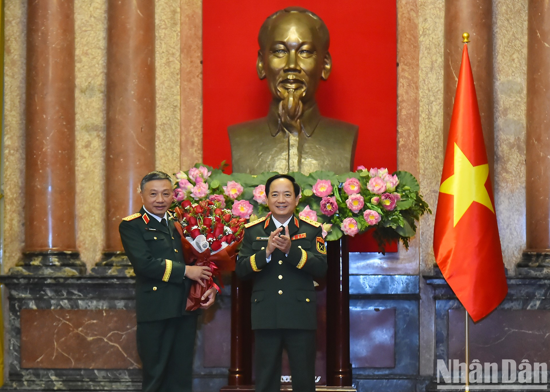 El jefe del Dirección General de Política del Ejército Popular de Vietnam, Trinh Van Quyet, entrega flores para felicitar a Le Quang Minh.