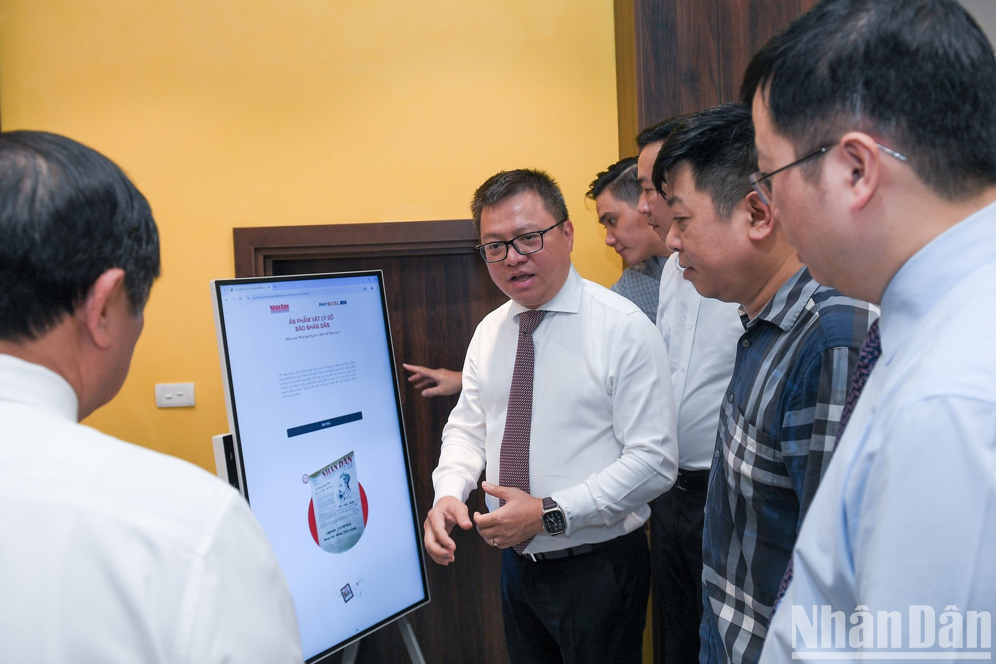 Quoc Minh presenta a los delegados la "Publicación física digital del periódico Nhan Dan".