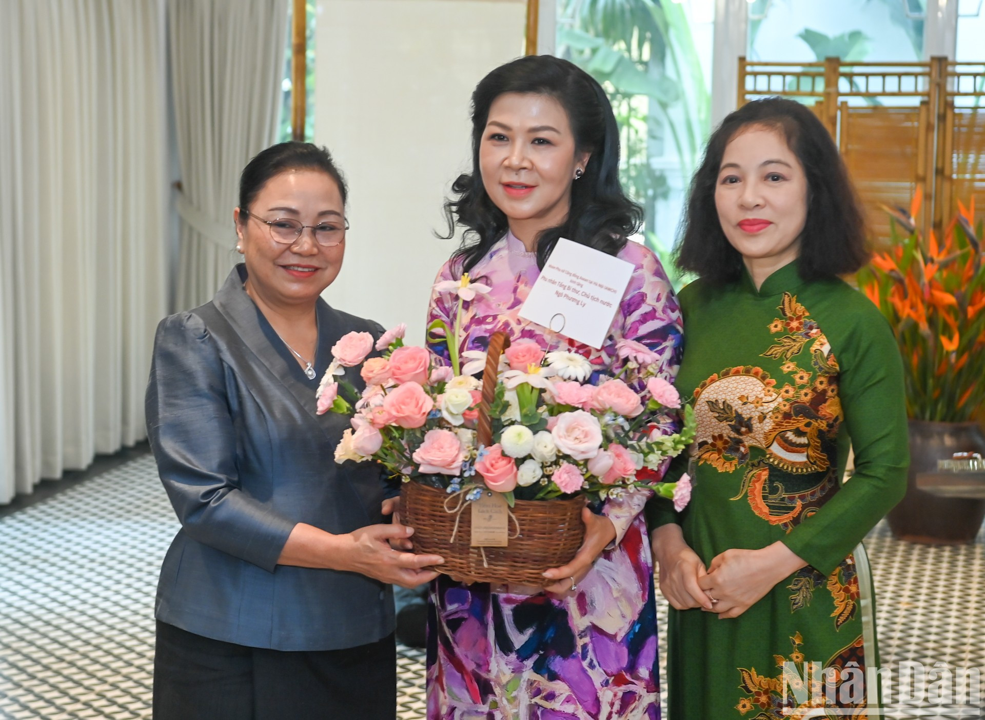 La embajadora de Laos en Vietnam, Khamphao Ernthavanh, y la presidenta honoraria del Grupo de Mujeres de la Comunidad de la Asean, Vu Thi Bich Ngoc, entregan flores a la esposa del secretario general del PCV y presidente de Vietnam, Ngo Phuong Ly.