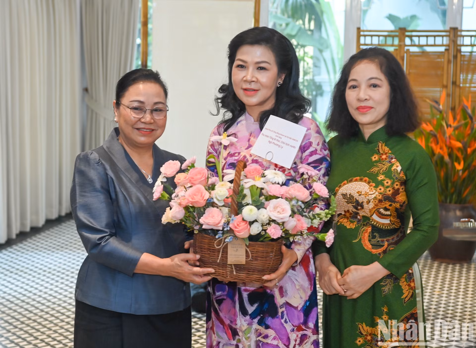 La embajadora de Laos en Vietnam, Khamphao Ernthavanh, y la presidenta honoraria del Grupo de Mujeres de la Comunidad de la Asean, Vu Thi Bich Ngoc, entregan flores a la esposa del secretario general del PCV y presidente de Vietnam, Ngo Phuong Ly.