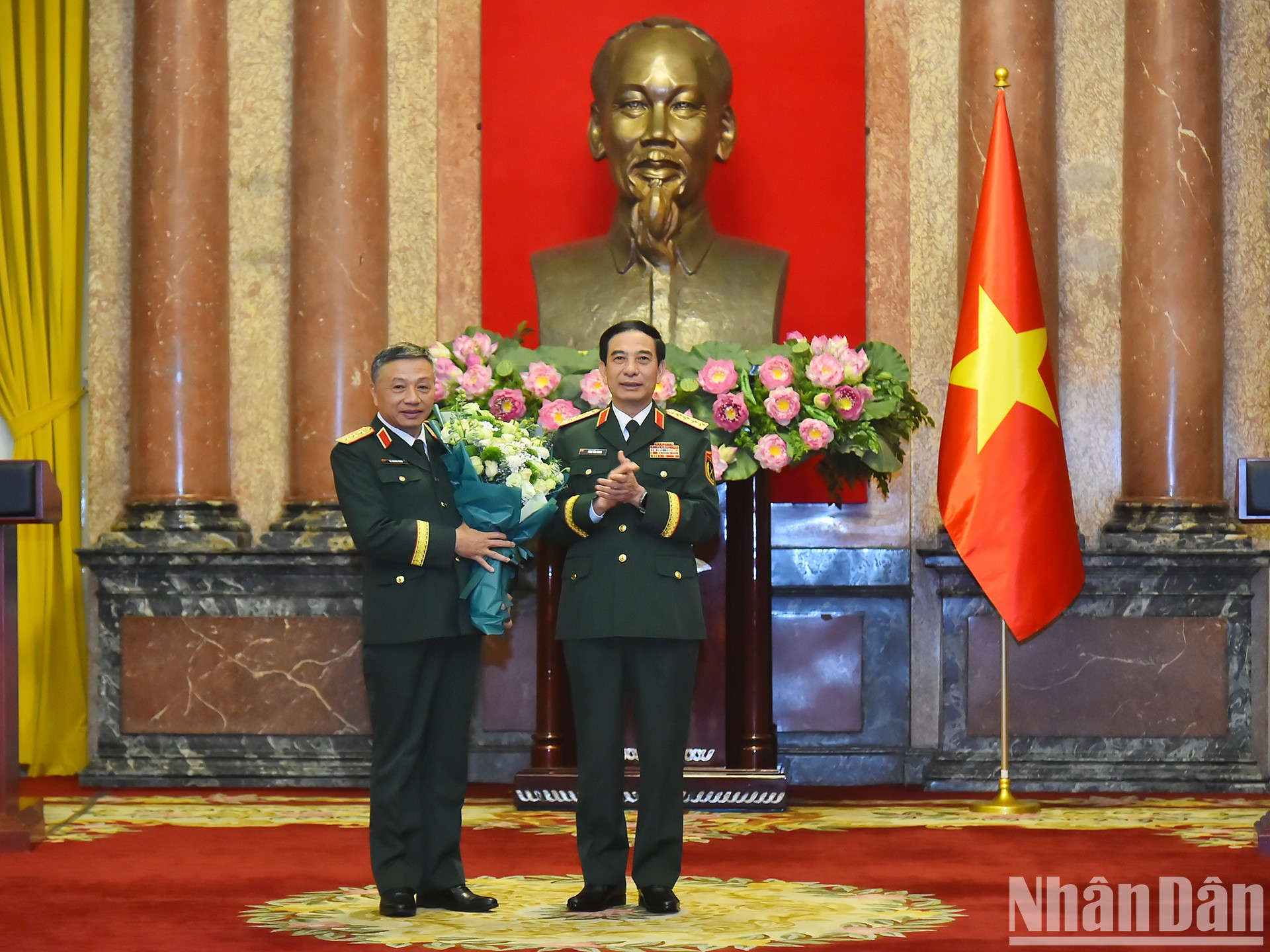 El ministro de Defensa, Phan Van Giang, entrega flores para felicitar al teniente general Le Quang Minh.