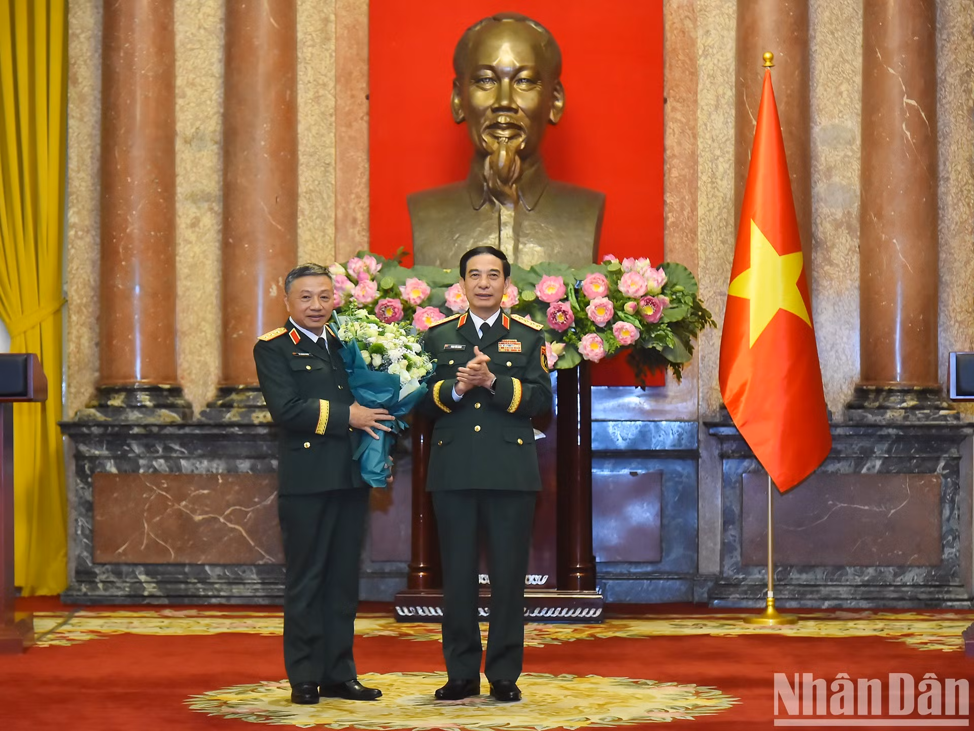El ministro de Defensa, Phan Van Giang, entrega flores para felicitar al teniente general Le Quang Minh.