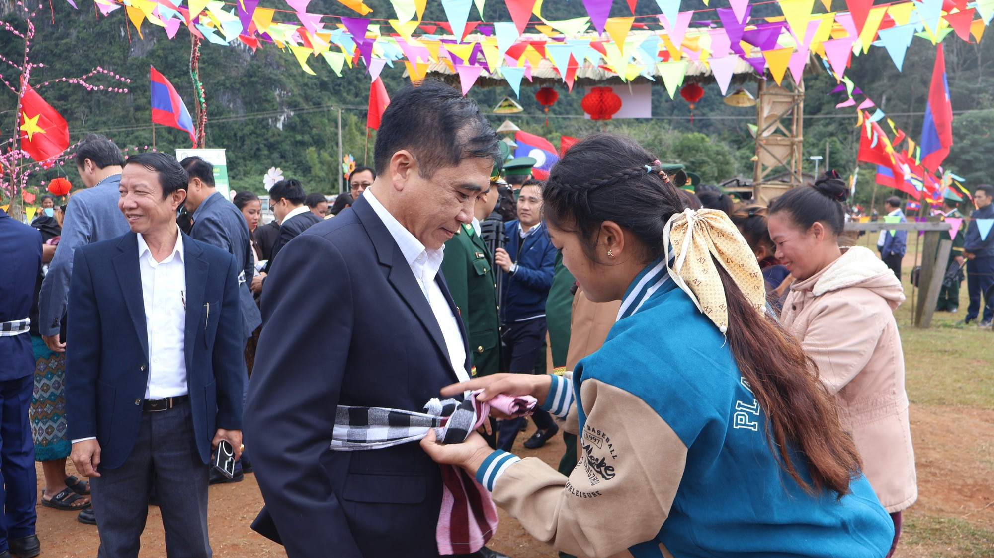Las muchachas laosianas anudan bufandas tradicionales a los visitantes. Las muchachas laosianas anudan bufandas tradicionales a los visitantes.