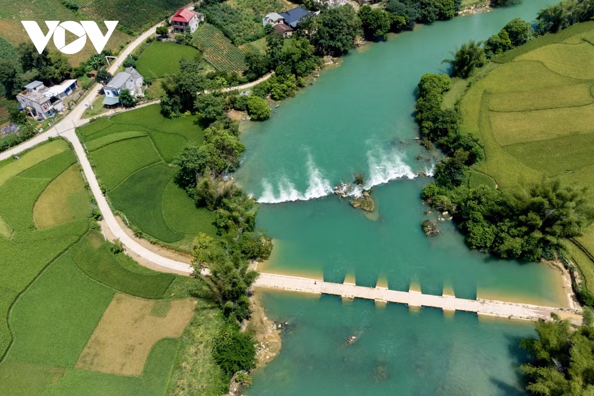 La corriente serpentea por el pueblo, flanqueado por bambúes en ambas orillas.