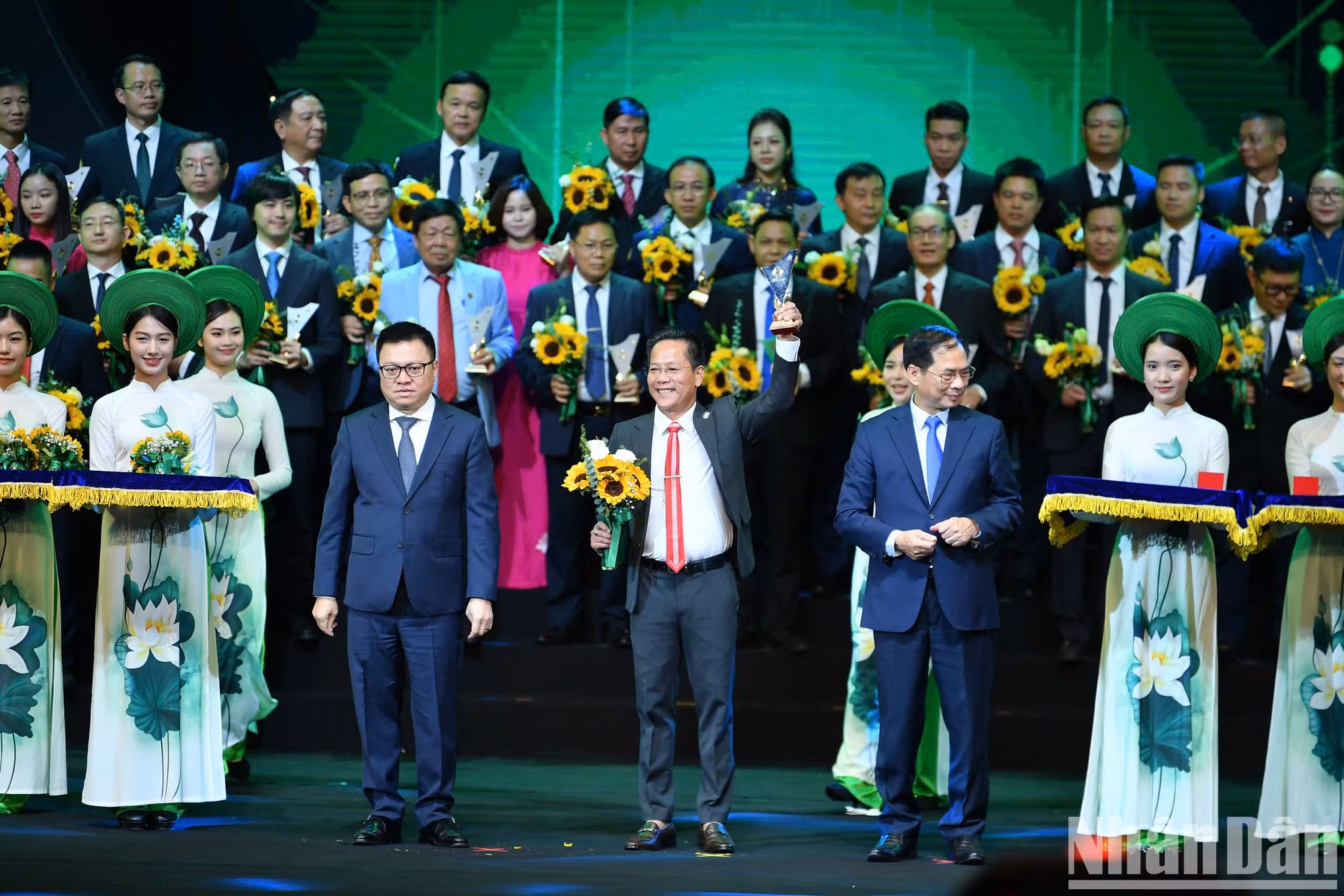 El vicepremier y canciller de vietnam, Bui Thanh Son, y presidente-editor del periódico Nhan Dan, Le Quoc Minh, entregan el logotipo a representantes de las empresas.