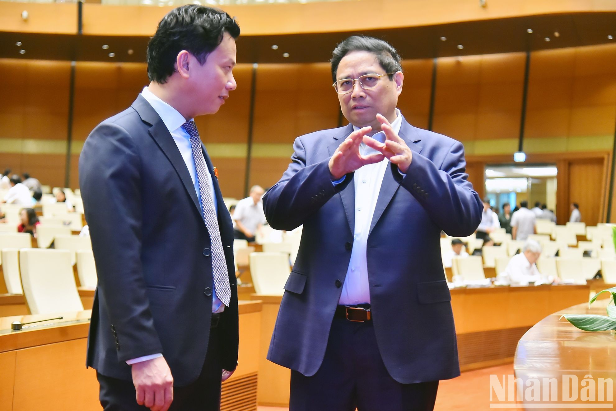 El primer ministro, Pham Minh Chinh, intercambia con el ministro de Recursos Naturales y Medio Ambiente, Dang Quoc Khanh.