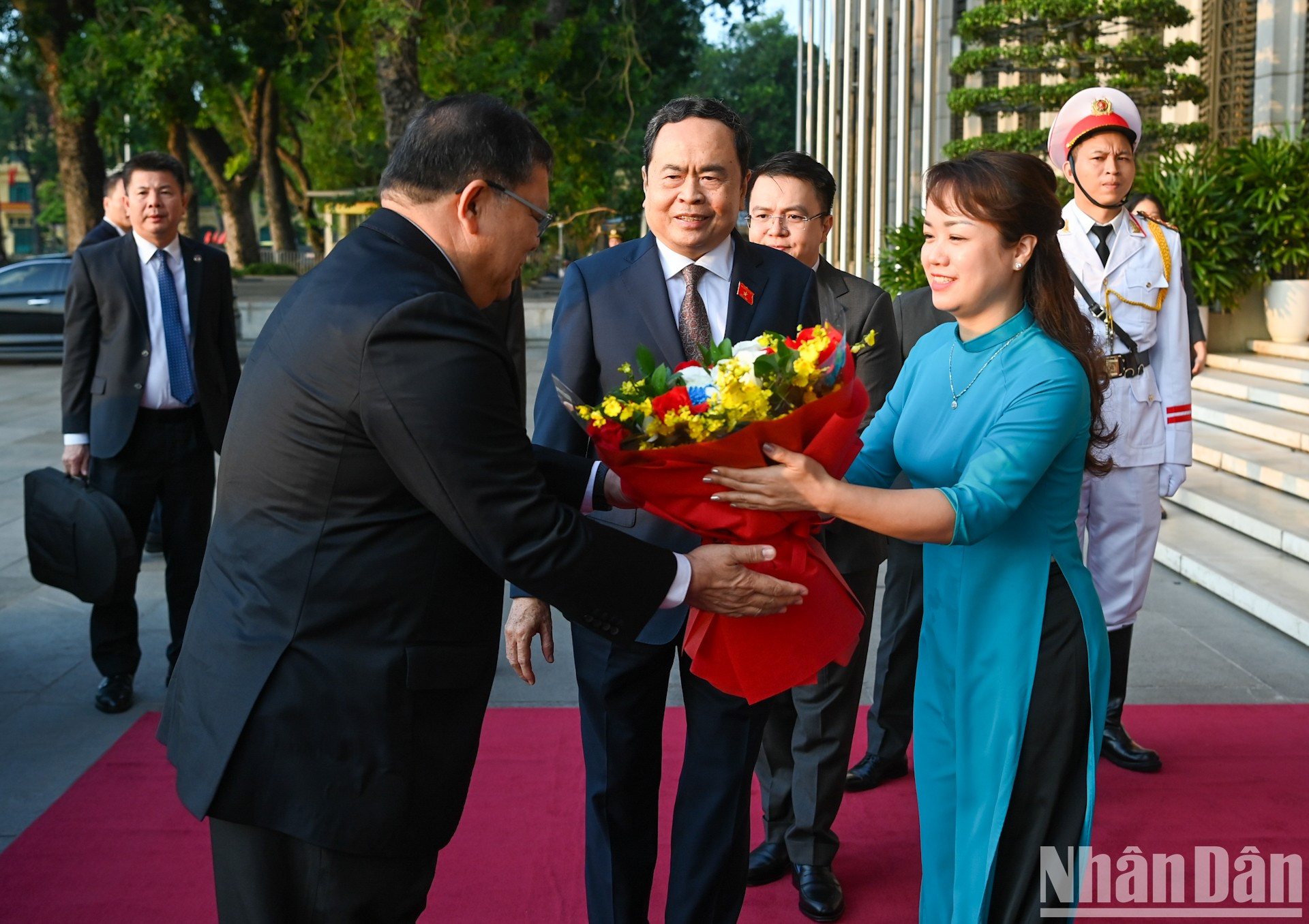 Una personal de la Oficina de la Asamblea Nacional regala flores de bienvenida al máximo legislador de Malasia.