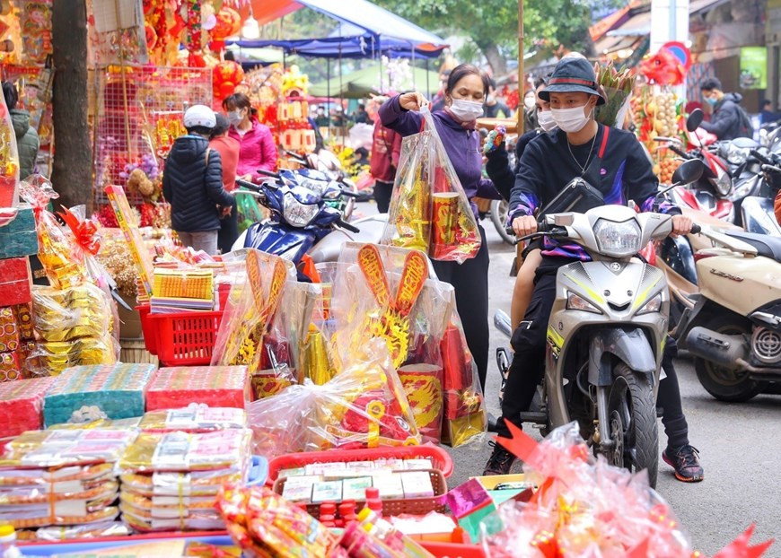 La gente compra ofrendas para Ong Cong y Ong Tao. (Fotografía: VNA)