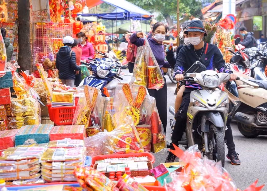 La gente compra ofrendas para Ong Cong y Ong Tao. (Fotografía: VNA)