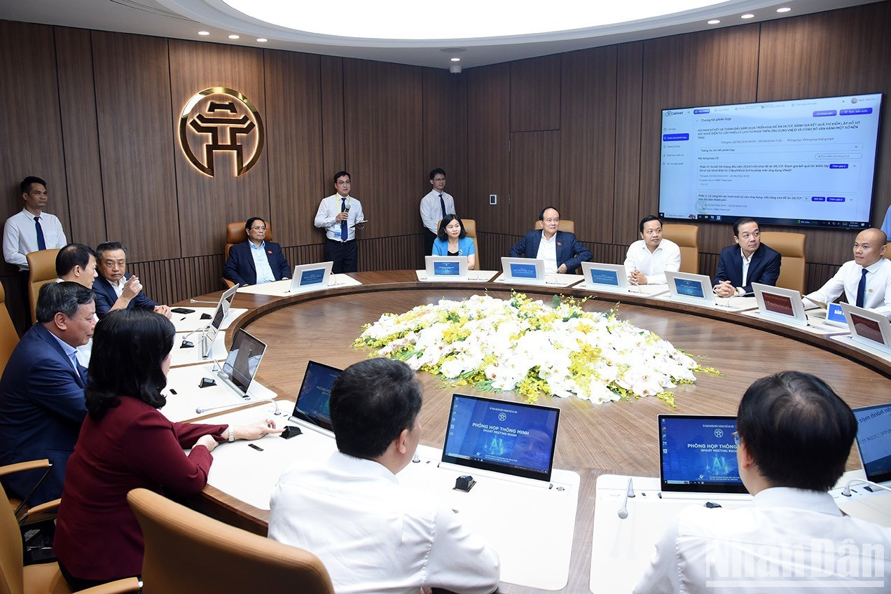 El primer ministro Pham Minh Chinh y los delegados experimentan aplicaciones de salas de reuniones inteligente en Hanói.