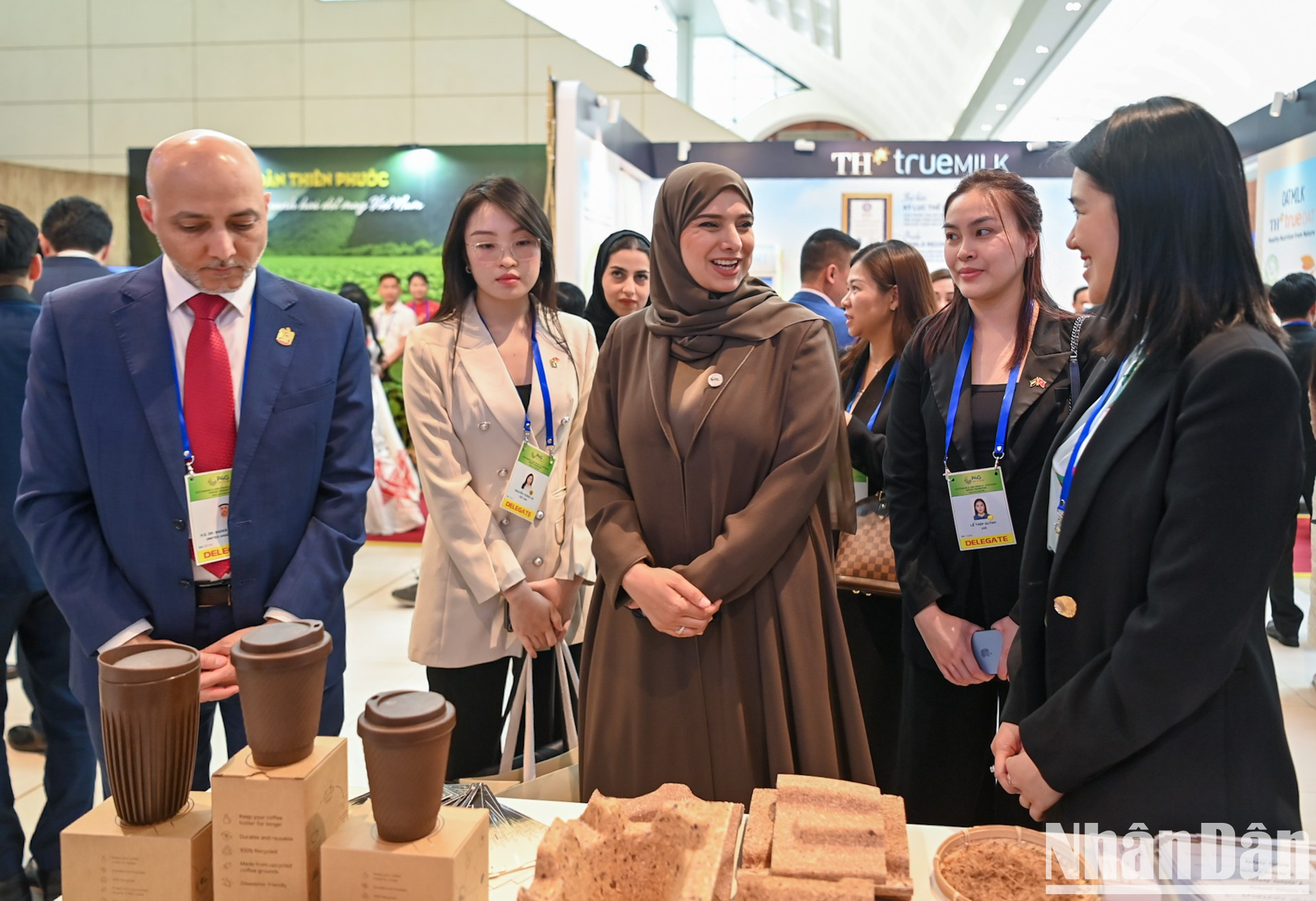 Visitantes internacionales investigan productos presentados en la exhibición. Visitantes internacionales investigan productos presentados en la exhibición.