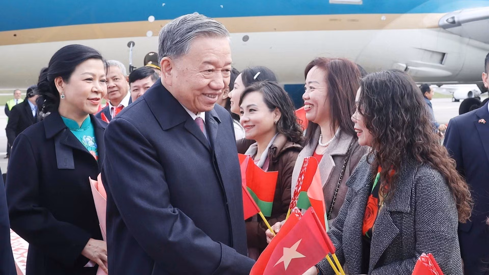 Vietnamitas residentes en Bielorrusia reciben al secretario general y su cónyuge en el aeropuerto de Minsk.