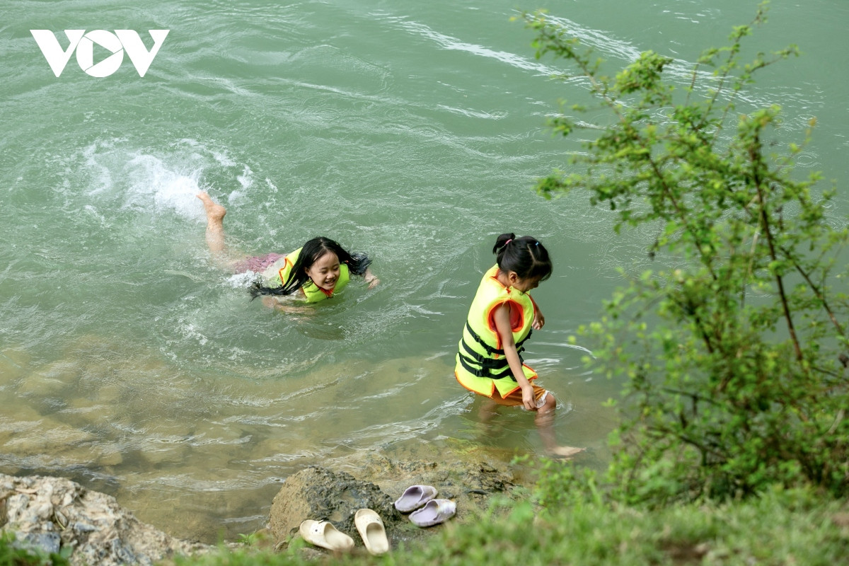 Niños nadan en el río.
