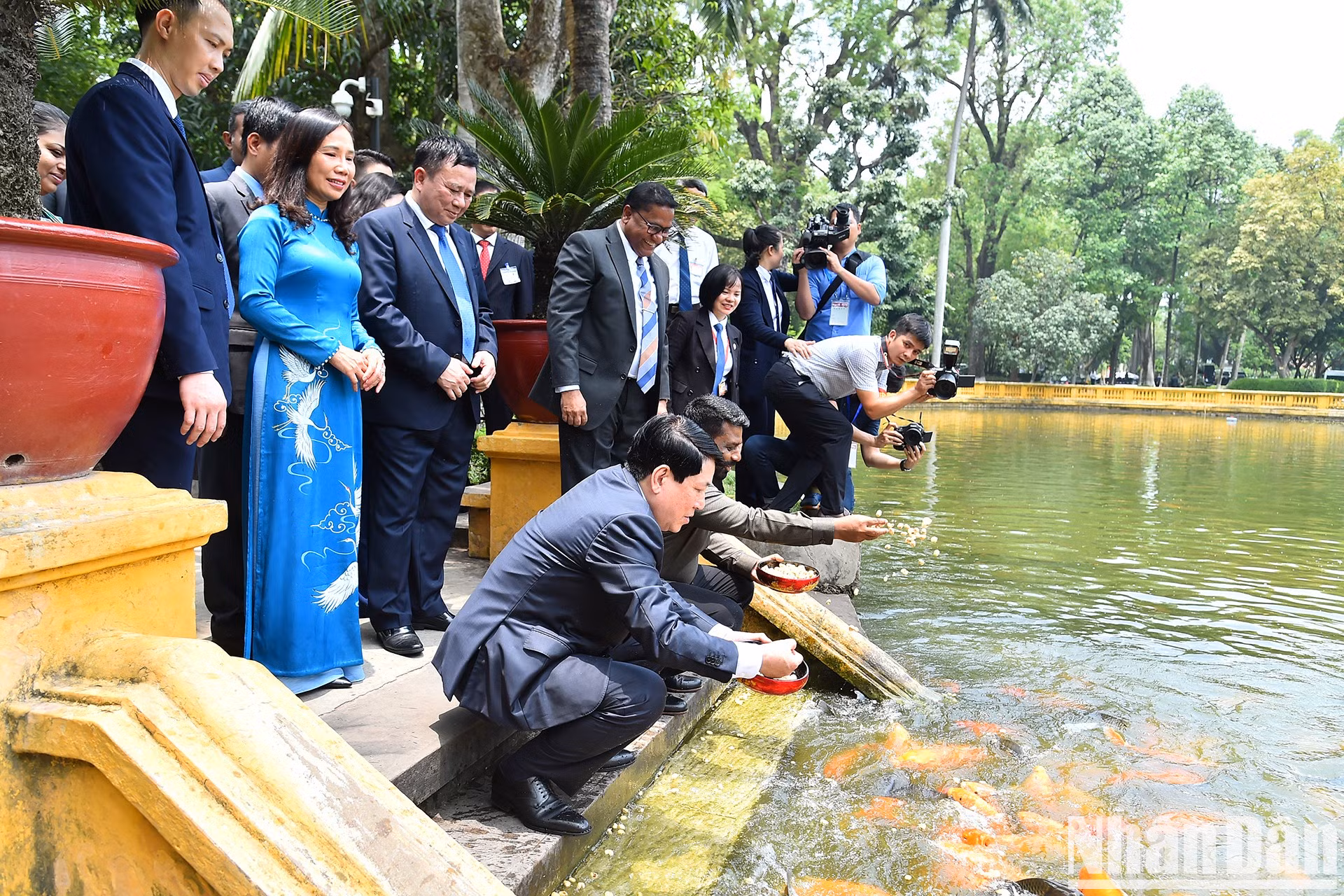 Los dos dirigentes alimentan a los peces en el estanque del Presidente Ho Chi Minh.