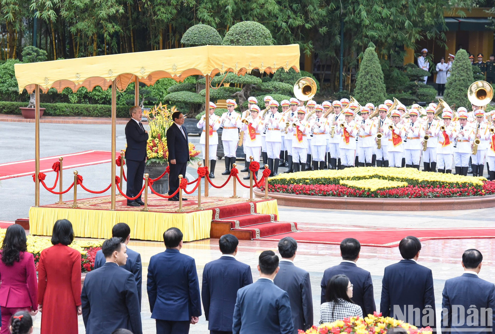 Ambos premieres se paran el podio de honor mientras se entonan los himnos de los dos países.
