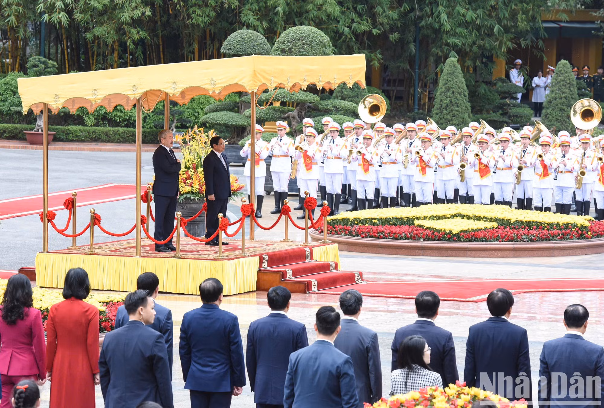 Ambos premieres se paran el podio de honor mientras se entonan los himnos de los dos países.