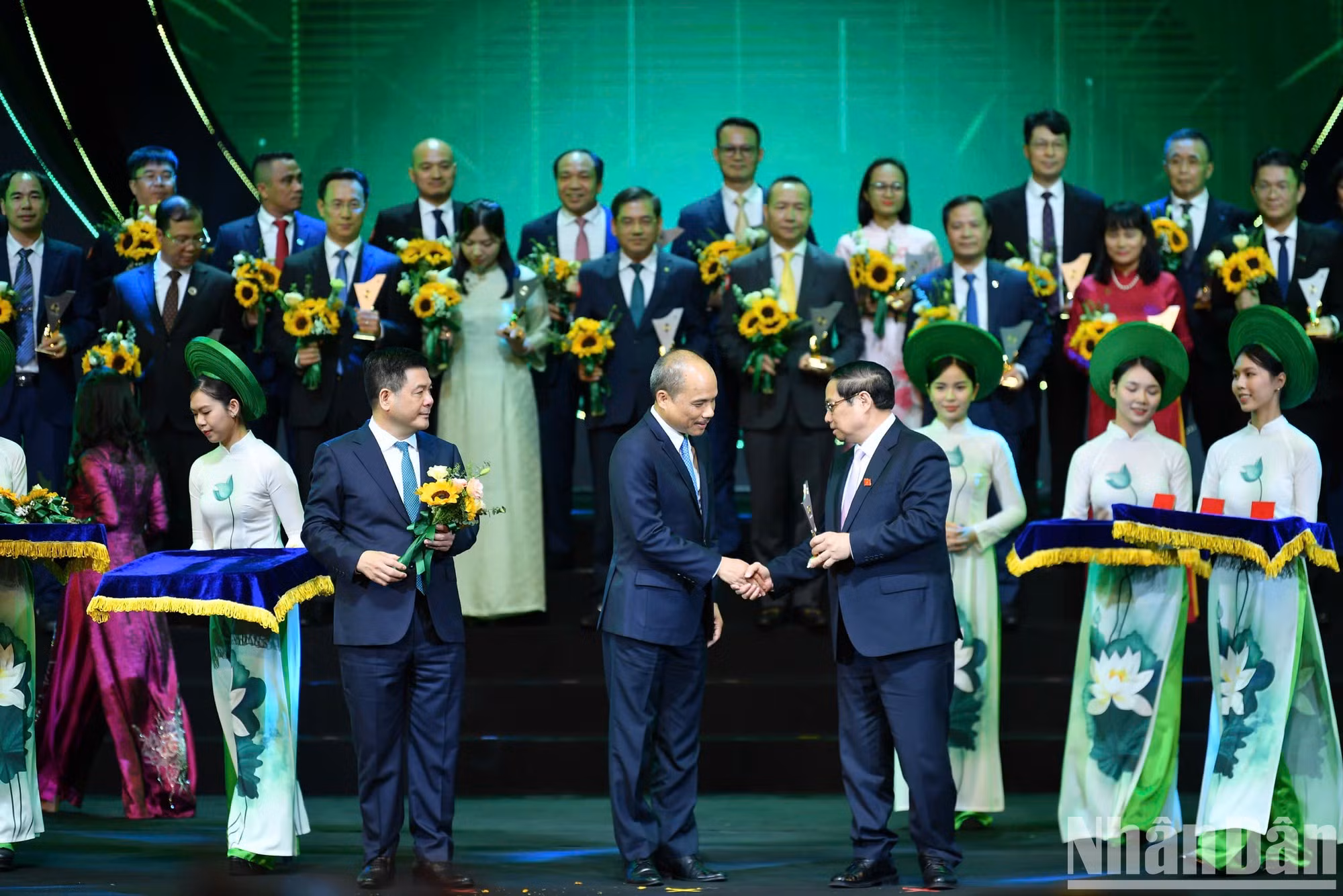 El jefe del Gobierno vietnamita Pham Minh Chinh y el titular Nguyen Hong Dien entregan el logotipo a representantes de las empresas cuyos productos logran la Marca Nacional de Vietnam 2024.