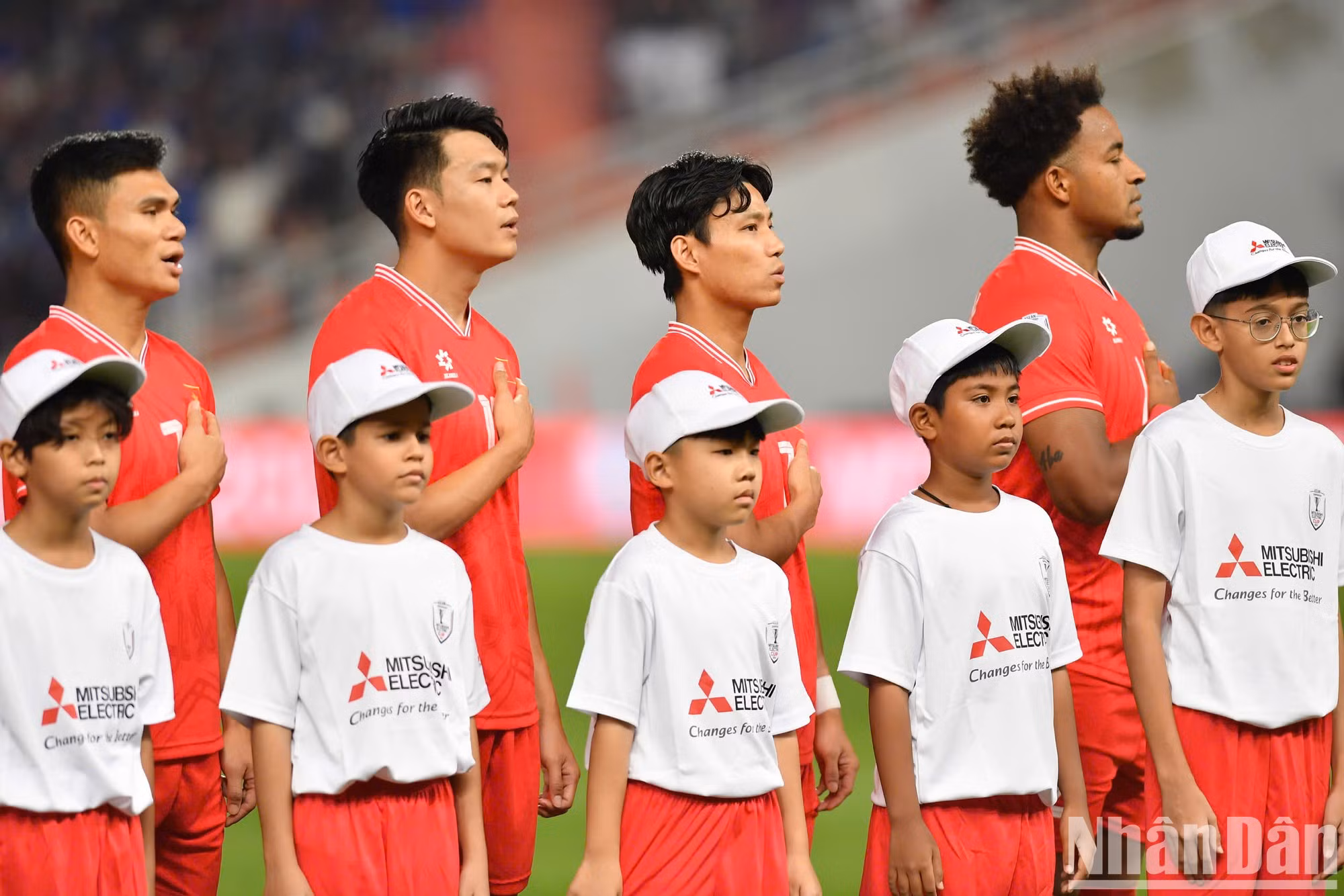 Los futbolistas vietnamitas saludan a la bandera y cantan el himno nacional antes de empezar el partido final.