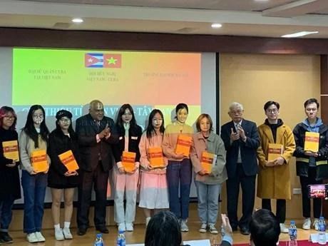 El autor Vu Van Au y el embajador de Cuba en Vietnam, Orlando Nicolás Hernández Guillén, presentan el diccionario vietnamita-español a estudiantes del Departamento de Español de la Universidad de Hanói (Fotografía: nhandan.vn)