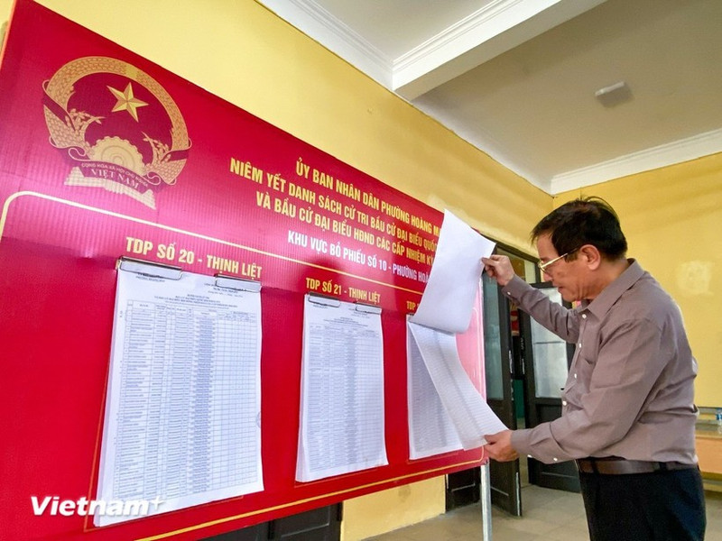 Un elector sigue la información de los candidatos. (Foto: VNA)