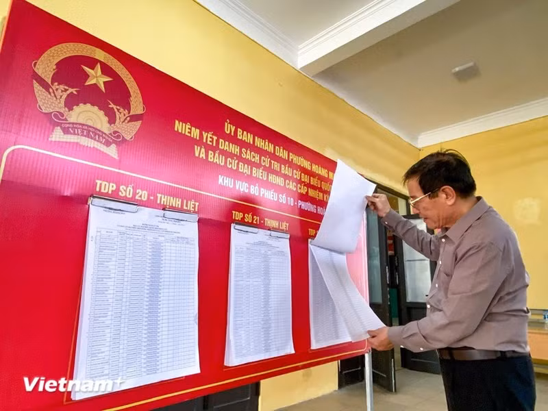 Un elector sigue la información de los candidatos. (Foto: VNA)