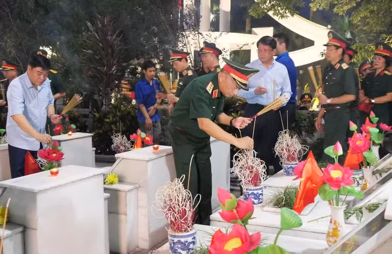 Dirigentes de la Dirección General de Política del Ejército Popular de Vietnam y de la provincia de Tuyen Quang colocan inciensos en las tumbas de combatientes fallecidos.