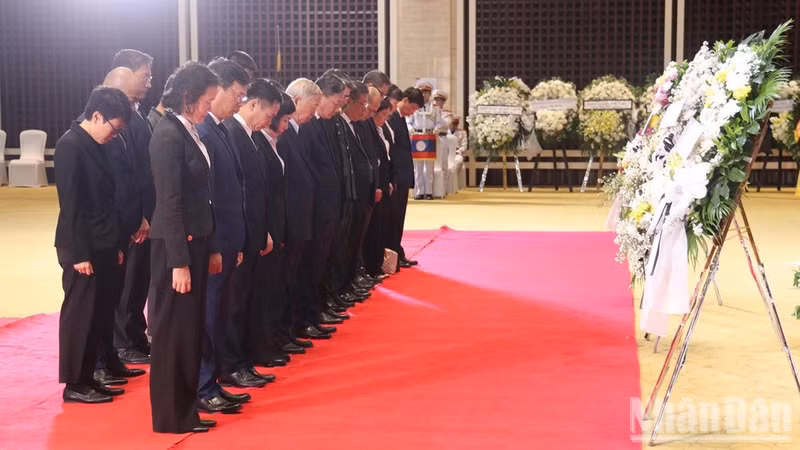 El embajador Nguyen Minh Tam y su comitiva colocan una corona floral y guardan un minuto de silencio como homenaje póstumo al presidente de la Asamblea Nacional de Laos Saysomphone Phomvihane. (Foto: Nhan Dan)