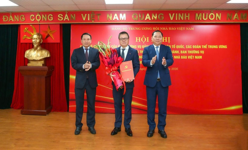 Le Quoc Minh (centro), miembro del Comité Central del Partido Comunista de Vietnam y del Buró Ejecutivo del Comité del Partido del Frente de la Patria y las asociaciones de masas centrales, presidente-editor del periódico Nhan Dan y titular de la Asociación de Periodistas de Vietnam, recibe la decisión de nombramiento. (Foto: Nhan Dan)