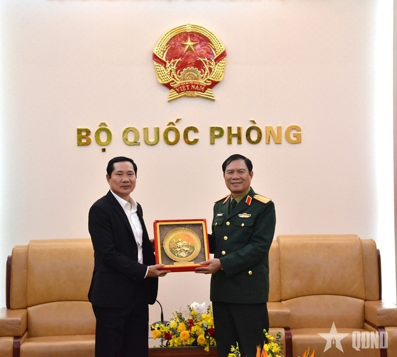 El jefe del Estado Mayor General del Ejército Popular de Vietnam y viceministro de Defensa, general Nguyen Tan Cuong (derecha), entrega un obsequio al coronel general Saichay Kommasith, viceministro de Defensa y jefe del Estado Mayor General del Ejército Popular de Laos. (Foto: qdnd.vn)