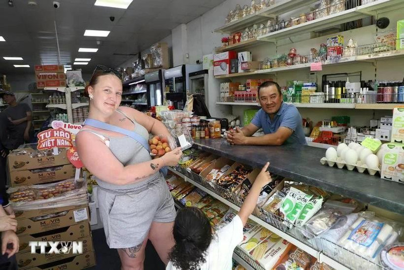 Una consumidora británica busca lichis vietnamitas en una tienda. (Fotografía: VNA)