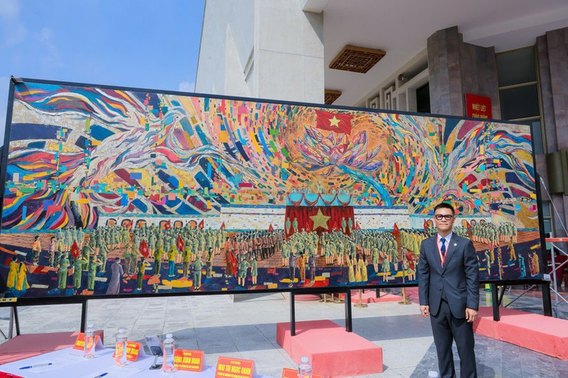 El pintor Chu Nhat Quang y su obra “Tío Ho lee la Declaración de Independencia”. (Foto: Nhan Dan)