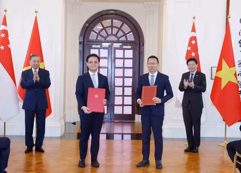 El secretario general del Partido Comunista y presidente de Vietnam, To Lam, y el primer ministro de Singapur, Lawrence Wong, presencian la firma de documentos de cooperación binacional.