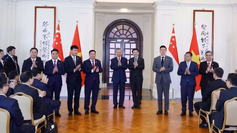El secretario general del Partido Comunista y presidente de Vietnam, To Lam, y el primer ministro de Singapur, Lawrence Wong, presencian la entrega de documentos de cooperación binacional.