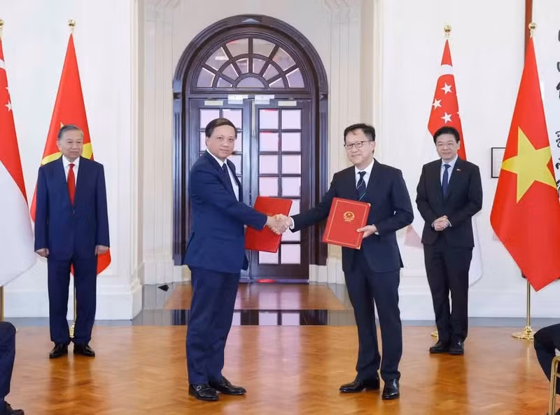 El secretario general del Partido Comunista y presidente de Vietnam, To Lam, y el primer ministro de Singapur, Lawrence Wong, presencian la firma de documentos de cooperación binacional.