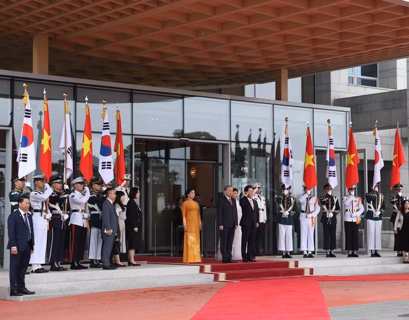 El presidente de Corea del Sur, Lee Jae Myung, y su esposa, junto con el secretario general del Partido Comunista de Vietnam, To Lam, y su cónyuge, en posición de honor, escuchan a la banda militar interpretar los himnos nacionales de sus países. (Foto: VNA)