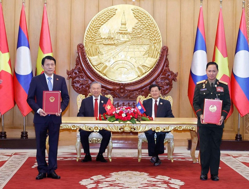 El secretario general del Partido Comunista de Vietnam, To Lam, y el secretario general del Partido Popular Revolucionario y presidente de Laos, Thongloun Sisoulith, presencian la firma de un memorando de entendimiento sobre cooperación entre el Ministerio de Seguridad Pública de Vietnam y el Ministerio de Defensa de Laos en el proyecto de construcción de una carretera de amistad entre los dos países. (Foto: VNA)