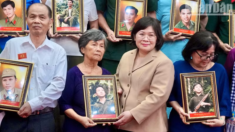 Van Thi Bach Tuyet, vicesecretaria del Comité del Partido Comunista de Vietnam en Ciudad Ho Chi Minh, entrega retratos restaurados de combatientes caídos a sus familiares. (Foto: Nhan Dan)