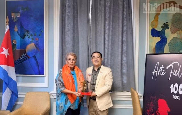 El jefe de la delegación vietnamita, Dinh Tien Dung, otorga un regalo de recuerdo a Marta Bonet.