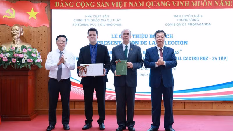 Tran Thanh Lam (primero a la izquierda), miembro del Comité Central del Partido Comunista de Vietnam y subjefe de su Comisión de Comunicación y Educación, y Vu Trong Lam (primero a la derecha), director y redactor jefe de la Editorial Política Nacional Su That (La Verdad), entregan la colección “Fidel Castro Ruz - Obras escogidas” a la Embajada de Cuba en Vietnam. (Foto: Nhan Dan)