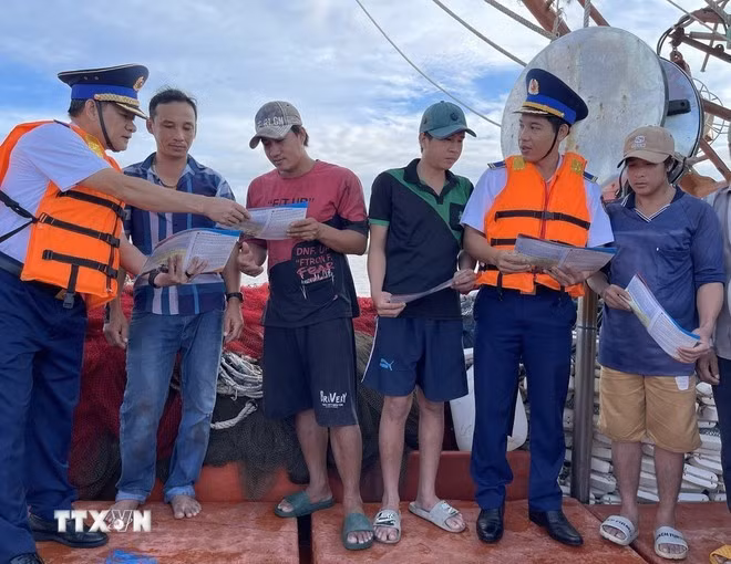 Las fuerzas encargadas de hacer cumplir la ley marítima difunden información sobre la pesca INDNR entre los pescadores. (Foto: VNA)