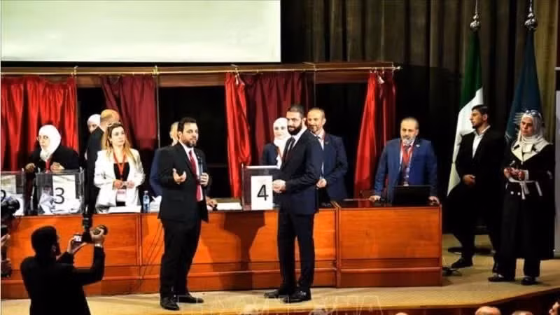 El presidente encargado de Siria, Ahmed al-Charaa (derecha, frente), deposita su papeleta para elegir un nuevo parlamento, en Damasco. (Foto: Xinhua/VNA)