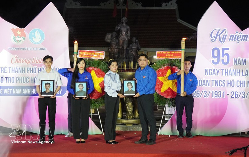 Ngo Minh Hai, secretario de la Unión de Jóvenes Comunistas Ho Chi Minh en Ciudad Ho Chi Minh y presidente de la filial municipal de la Federación de Juventud de Vietnam, entrega retratos a la familia de la Heroica Madre Vietnamita Nguyen Thi Dau y sus dos hijos, los mártires Tran Thi Sau y Tran Van Chan. (Foto: VNA)