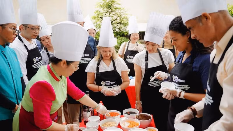 Chefs vietnamitas y sus “aprendices” foráneos en la sesión. (Foto: Asociación de Cultura Culinaria de Vietnam)