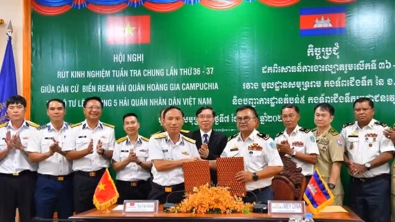 El contralmirante Ngo Van Thanh y el vicealmirante May Dina se entregan el memorando de entendimiento sobre coordinación en patrullajes conjuntos. (Foto: Nhan Dan)