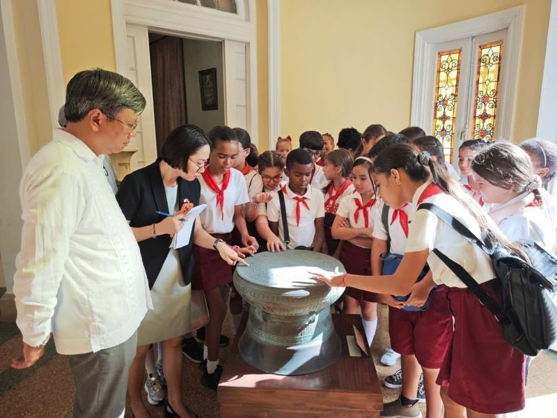 Alumnos habaneros curiosos por un prototipo del Tambor de bronce, símbolo de la cultura vietnamita. (Fotografía: Embajada de Vietnam en Cuba)