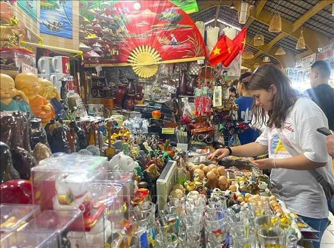 Turistas extranjeros eligen productos artesanales en Ciudad Ho Chi Minh para comprar como recuerdo. (Foto: VNA)