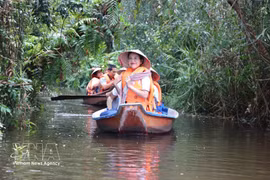 Los turistas disfrutan de la experiencia de navegar en canoa para explorar la Reserva Ecológica Dong Thap Muoi en la comuna de Tan Phuoc 2, provincia de Dong Thap. (Fuente: VNA)